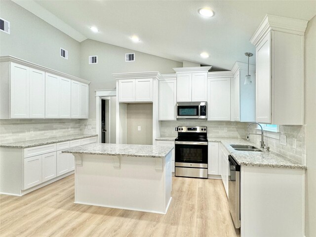 kitchen featuring white cabinetry, light hardwood / wood-style flooring, a kitchen island, and stainless steel appliances