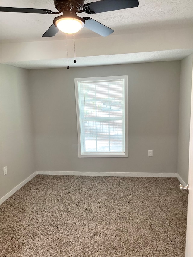 carpeted spare room with a textured ceiling and ceiling fan