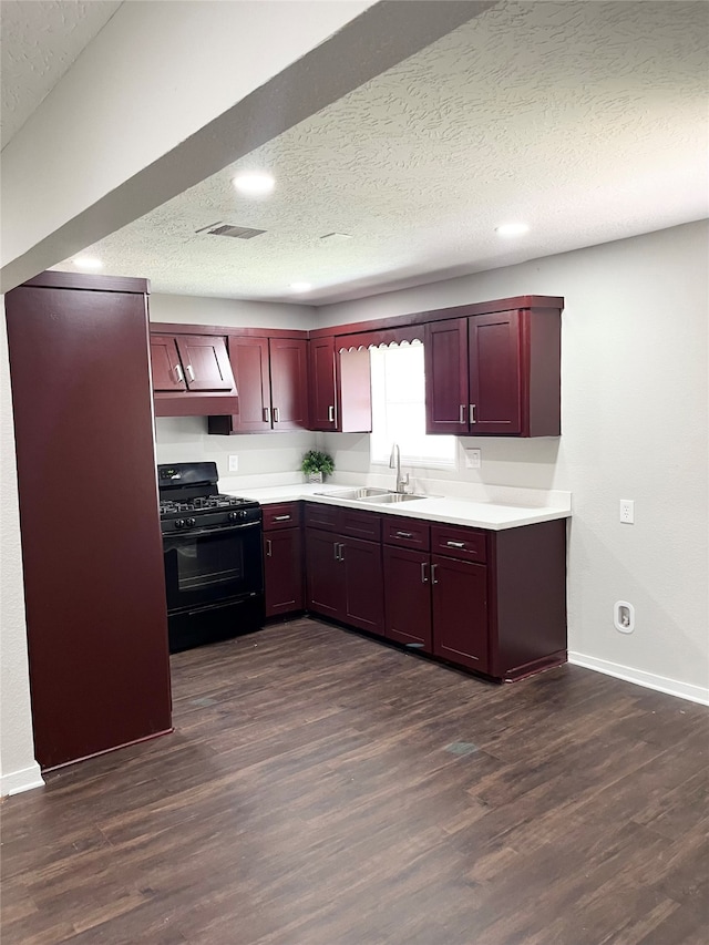 kitchen featuring black gas stove, custom exhaust hood, dark hardwood / wood-style floors, and sink