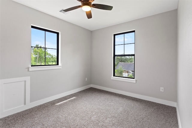 carpeted empty room with ceiling fan and plenty of natural light