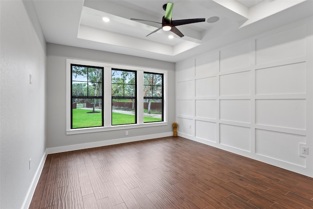 spare room featuring ceiling fan, hardwood / wood-style flooring, and a raised ceiling