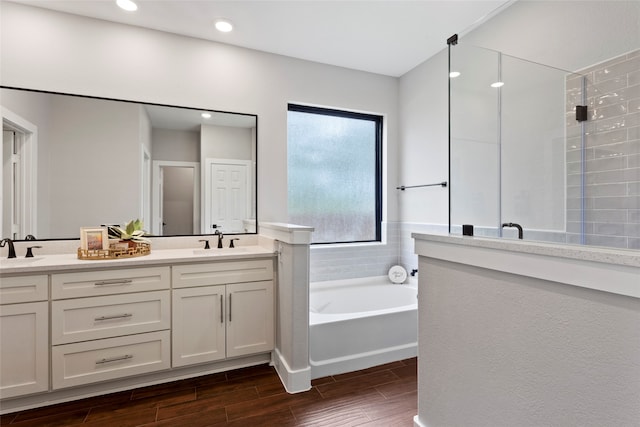 bathroom with independent shower and bath and dual bowl vanity