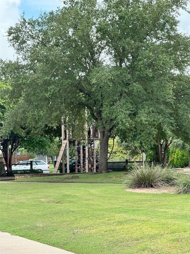 surrounding community with playground community, a lawn, and fence