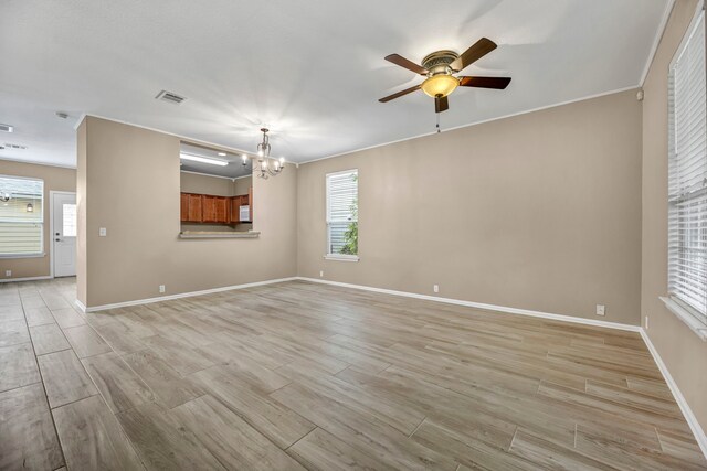 unfurnished living room featuring light hardwood / wood-style floors, ornamental molding, and ceiling fan with notable chandelier