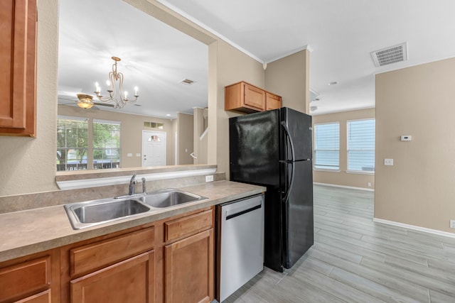 kitchen featuring sink, hanging light fixtures, black refrigerator, light hardwood / wood-style floors, and dishwasher