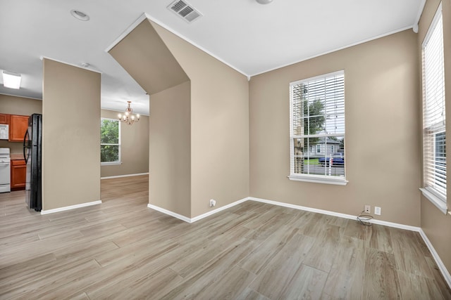 unfurnished room featuring baseboards, visible vents, crown molding, light wood-type flooring, and a notable chandelier