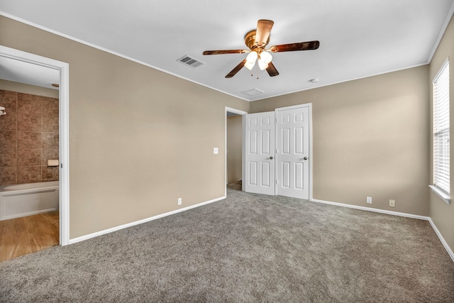 unfurnished bedroom featuring carpet floors, visible vents, and multiple windows