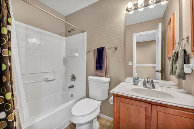 full bathroom with a textured wall, vanity, toilet, and shower / bath combo with shower curtain