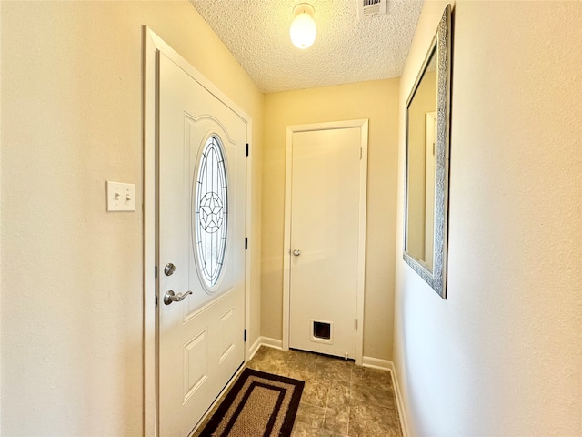 foyer entrance with a textured ceiling