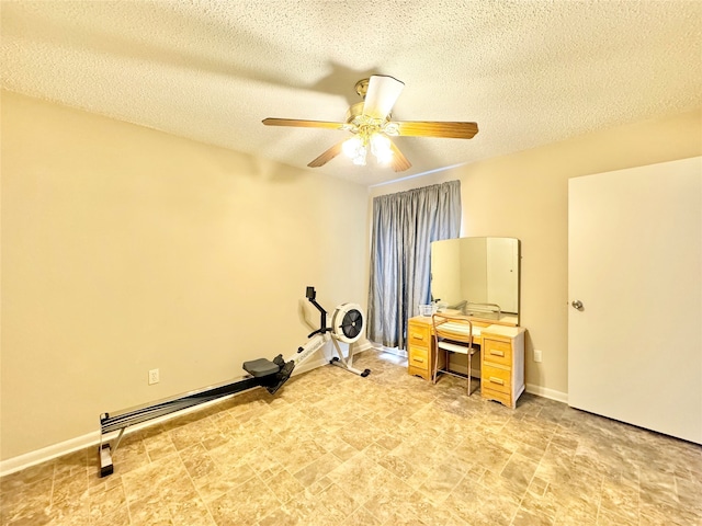 workout area featuring a textured ceiling and ceiling fan