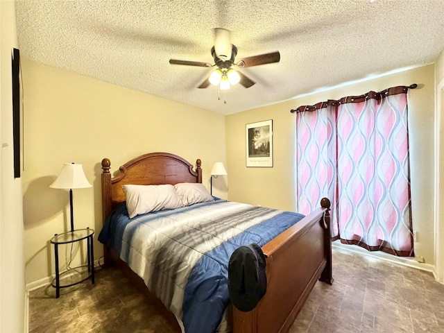 bedroom with ceiling fan and a textured ceiling