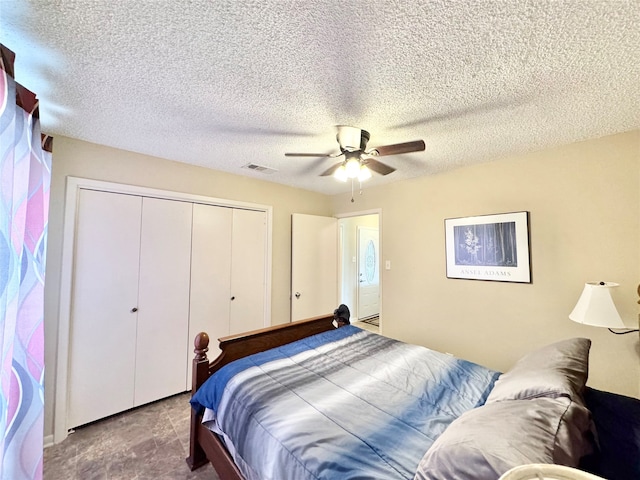 carpeted bedroom featuring a textured ceiling, ceiling fan, and a closet