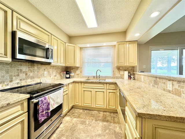 kitchen featuring appliances with stainless steel finishes, plenty of natural light, decorative backsplash, and sink