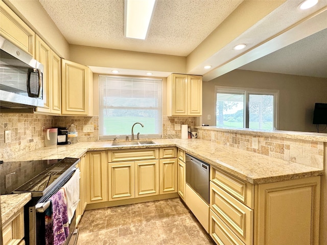 kitchen featuring light stone counters, stainless steel appliances, sink, and tasteful backsplash