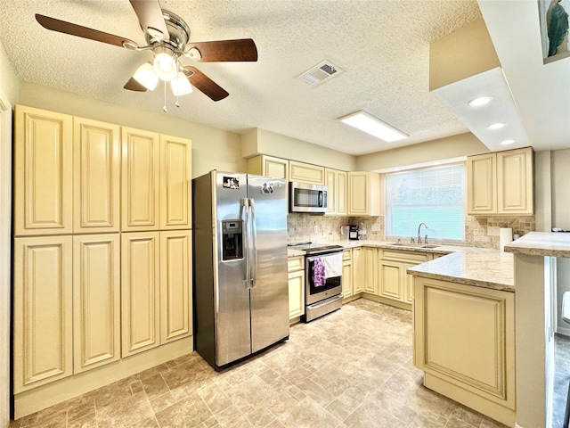 kitchen featuring ceiling fan, stainless steel appliances, a textured ceiling, and sink