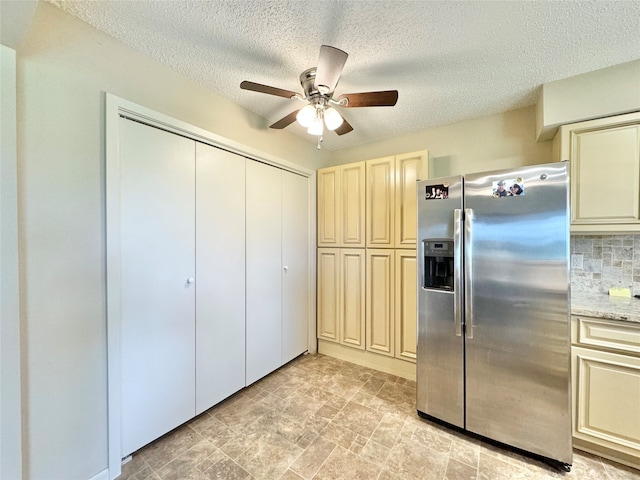 kitchen featuring a textured ceiling, backsplash, stainless steel fridge with ice dispenser, cream cabinetry, and ceiling fan