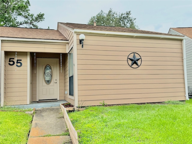 doorway to property with a lawn