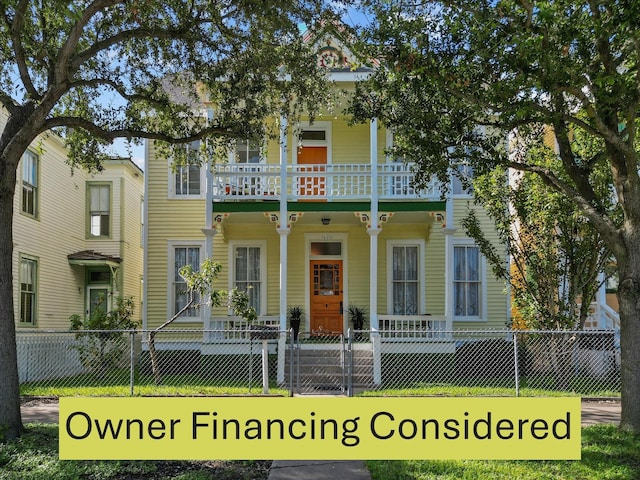 view of front of property with a front yard, covered porch, and a balcony