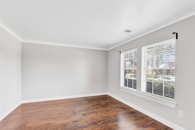 spare room featuring dark wood-type flooring and ornamental molding