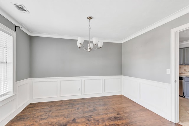 unfurnished room with crown molding, dark hardwood / wood-style floors, a chandelier, and a wealth of natural light