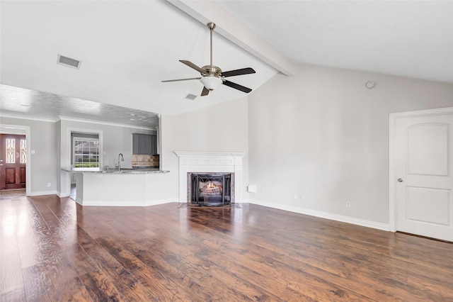 unfurnished living room featuring ceiling fan, sink, dark hardwood / wood-style floors, and lofted ceiling with beams