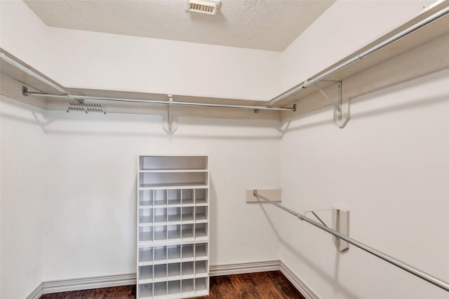 spacious closet with dark hardwood / wood-style flooring