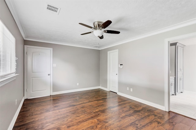 unfurnished room featuring dark wood-type flooring, ceiling fan, ornamental molding, and a textured ceiling