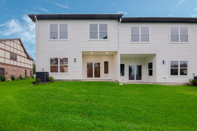 rear view of property with a yard and central AC