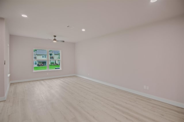 empty room with ceiling fan and light hardwood / wood-style floors