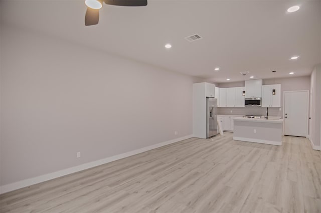 unfurnished living room featuring ceiling fan and light hardwood / wood-style floors