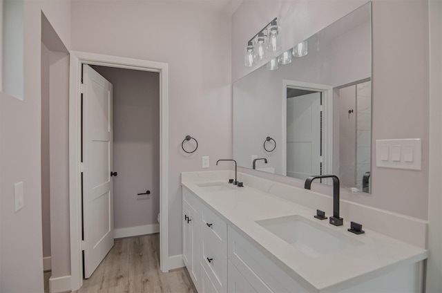 bathroom with hardwood / wood-style floors, vanity, and toilet