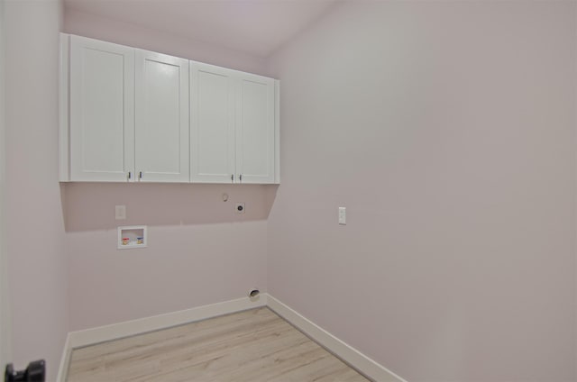 washroom featuring electric dryer hookup, light hardwood / wood-style flooring, cabinets, and washer hookup