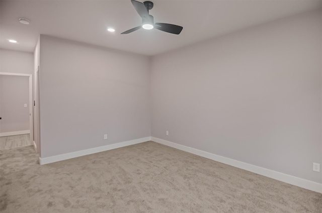 spare room featuring ceiling fan and light colored carpet