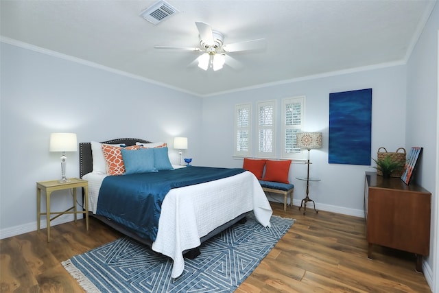 bedroom with crown molding, ceiling fan, and dark hardwood / wood-style flooring