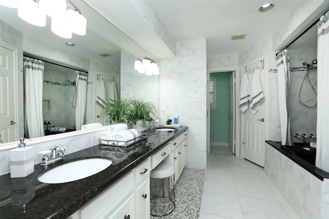 bathroom featuring tile patterned flooring, vanity, tile walls, and walk in shower