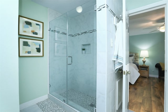 bathroom with hardwood / wood-style flooring, ceiling fan, and walk in shower