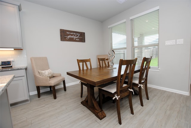 dining area with light hardwood / wood-style floors and a healthy amount of sunlight