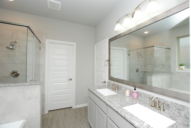 bathroom with walk in shower, hardwood / wood-style flooring, and double sink vanity