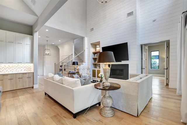 411 N Copa Palm Loop, Montgomery, TX 77316 - living area with visible vents, light wood finished floors, a fireplace, and a towering ceiling