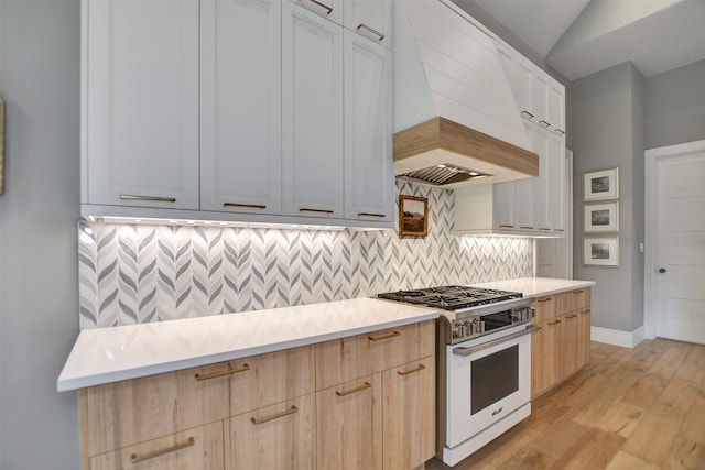 411 N Copa Palm Loop, Montgomery, TX 77316 - kitchen with custom range hood, high end range, light countertops, light brown cabinetry, and backsplash
