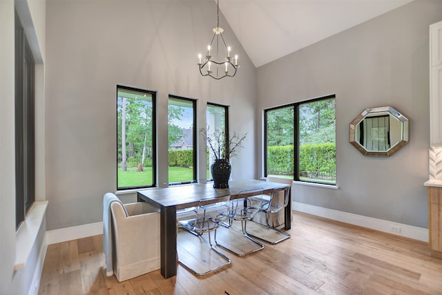 home office featuring light hardwood / wood-style floors, a notable chandelier, and high vaulted ceiling