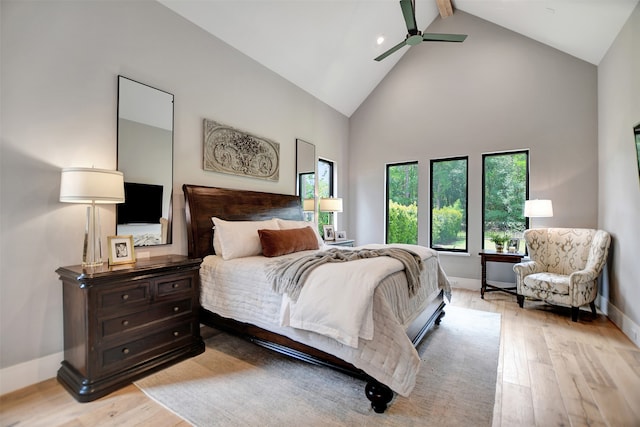 bedroom featuring beam ceiling, ceiling fan, light wood-type flooring, and high vaulted ceiling