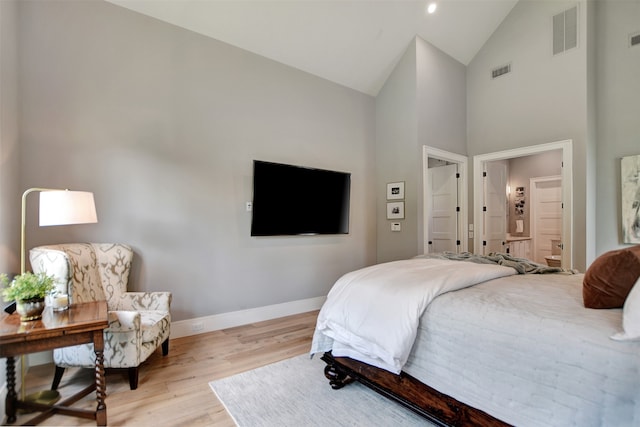 bedroom featuring light wood-type flooring and high vaulted ceiling