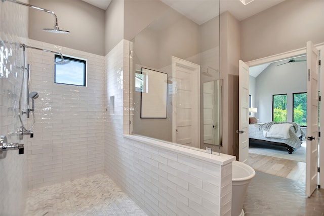 bathroom with ceiling fan, a tile shower, and wood-type flooring