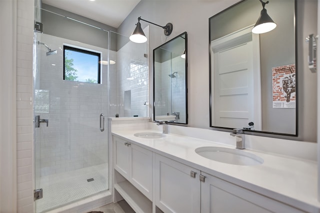 bathroom with dual vanity and an enclosed shower