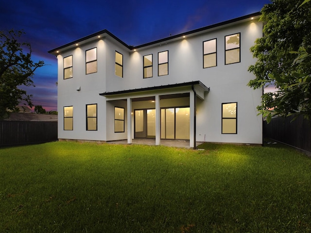 back of house with a patio, a fenced backyard, a lawn, and stucco siding