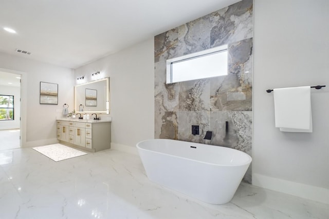 full bath with vanity, visible vents, baseboards, a soaking tub, and marble finish floor