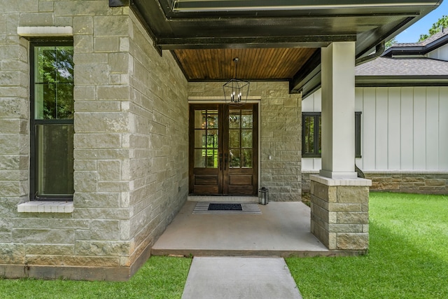 view of exterior entry featuring a porch and a lawn