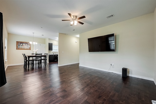 living room featuring dark hardwood / wood-style floors and ceiling fan with notable chandelier