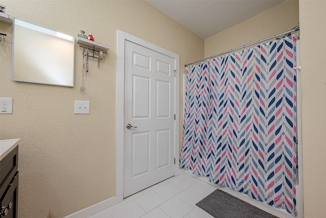 bathroom with tile patterned flooring, vanity, and curtained shower